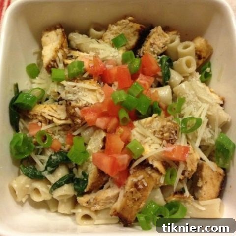 Beautifully plated creamy spinach, mushroom, and chicken pasta, garnished with fresh herbs