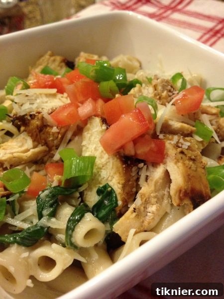 Delicious and healthy creamy chicken pasta with spinach and mushrooms, garnished with fresh herbs
