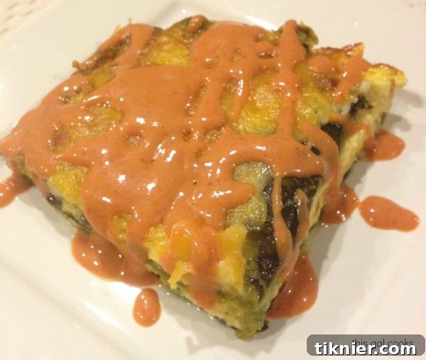 A close-up of a slice of Chili Relleno Casserole, showcasing the layers of pepper, cheese, and egg.