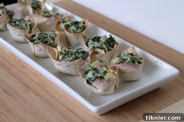 Close-up of baked Spinach and Artichoke Wontons in a muffin tin