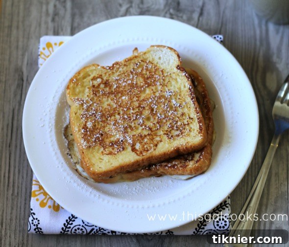 Close-up of golden-brown Brown Sugar French Toast stacked on a plate.