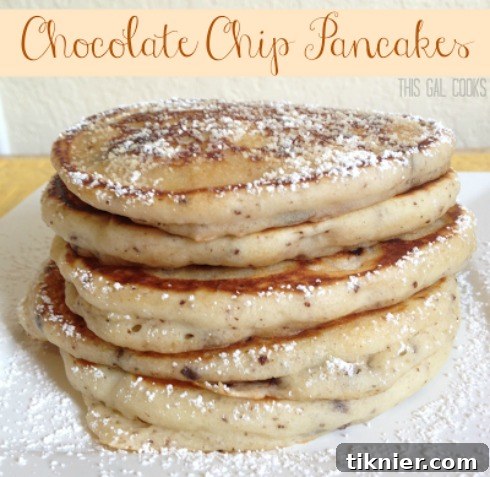 Stack of fluffy chocolate chip pancakes with syrup.