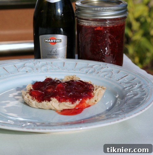 Homemade Blueberry Bliss 7 Homemade Strawberry Champagne Jam in a jar with fresh strawberries around it.