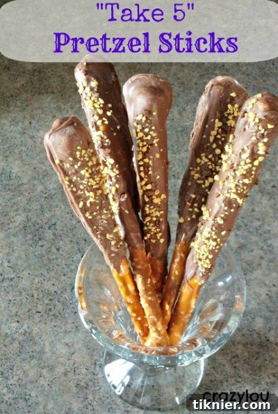 Irresistible Take 5 Pretzel Sticks, generously coated in chocolate and topped with crunchy peanuts and a drizzle of caramel, delivering a perfect sweet and salty balance.