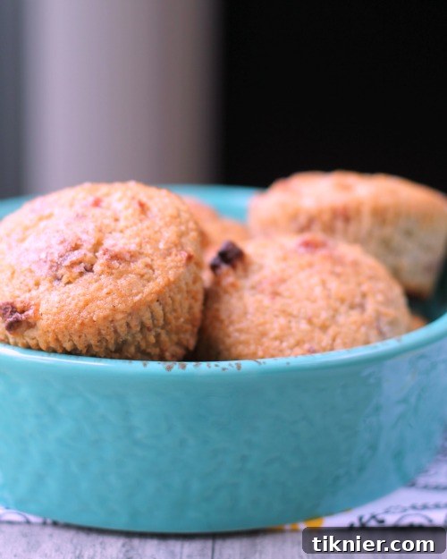 Close-up of baked Vegan Apple Berry Bran Muffins with dried fruit visible, showcasing their appealing texture.