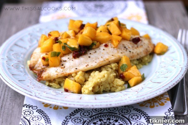 Close-up shot of Broiled Tilapia topped with fresh Chipotle Peach Salsa, presented beautifully on a white plate.