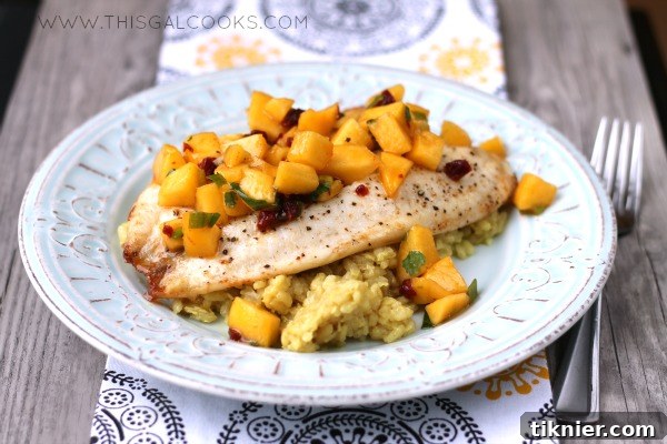 A beautifully plated serving of Broiled Tilapia with Chipotle Peach Salsa and Coconut Curry Risotto.