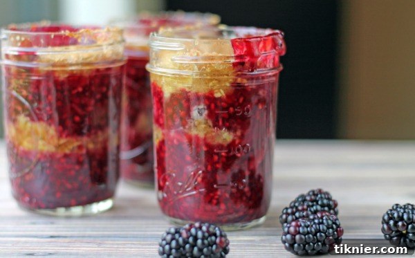 Two individual Blackberry Crisps in Jars with a spoon, highlighting the delicious fruit filling and crispy topping. Perfect for single servings. #blackberries #fruitcrisp #jarrecipes