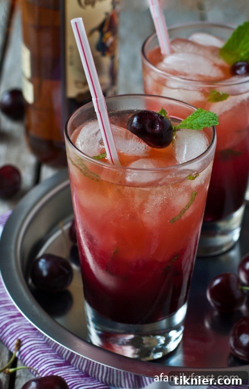 Rich Fresh Cherry and Spiced Rum Cocktail with cherry garnish