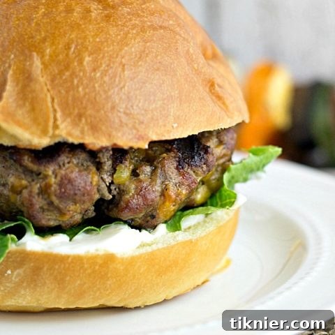 Close-up of a juicy Jalapeno Cheddar Burger with melted cheese, fresh lettuce, and ripe tomatoes