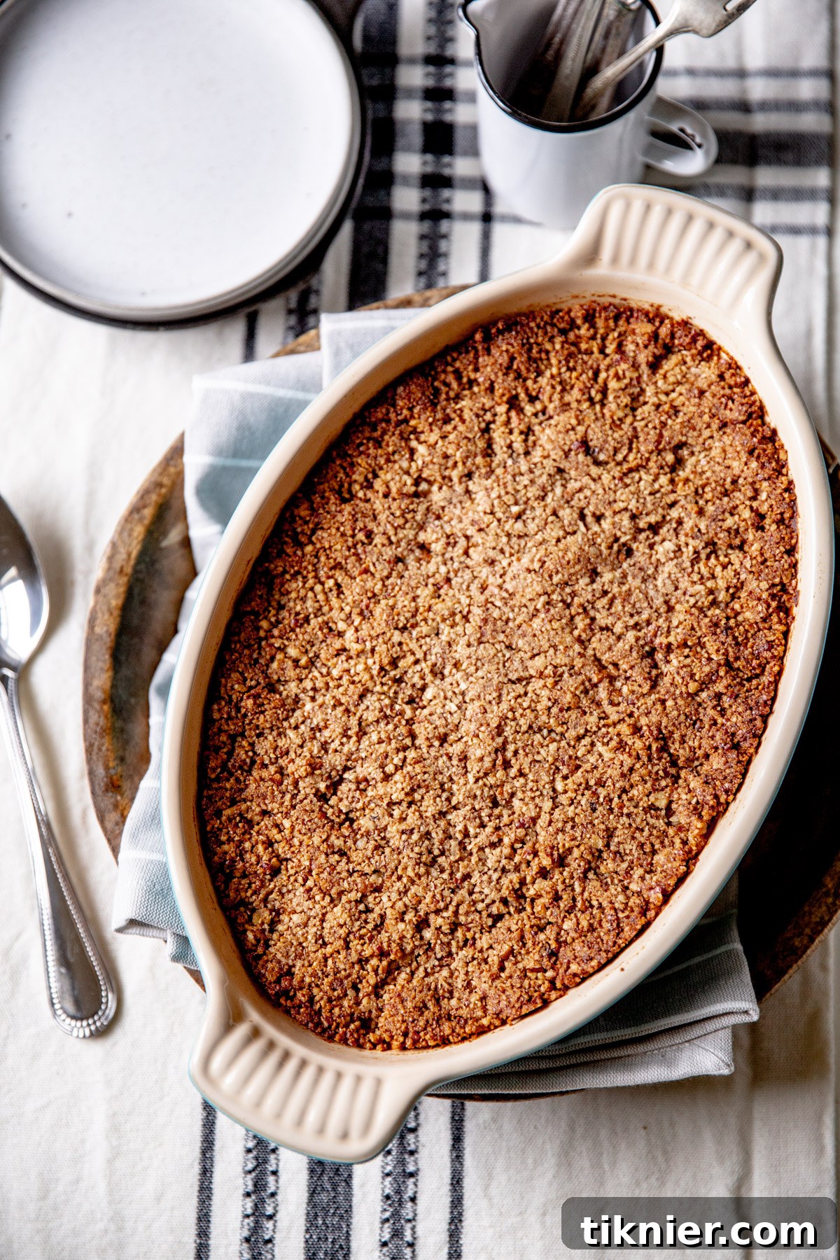 Close-up of a sweet potato casserole baking dish with a rich, creamy filling and a crispy streusel topping.