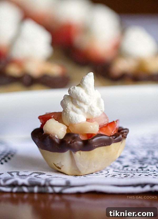 Hands preparing delightful Strawberry Banana Phyllo Cups, dipping phyllo shells in melted Ghirardelli chocolate