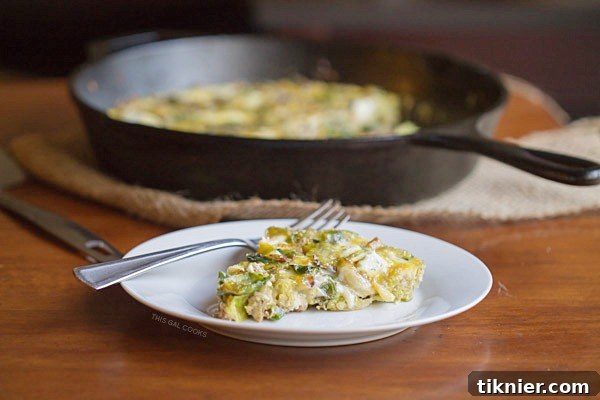 Close-up of a rustic Brussels Sprouts, Bacon and Goat Cheese Frittata, garnished with fresh herbs, suitable for a hearty breakfast or brunch.