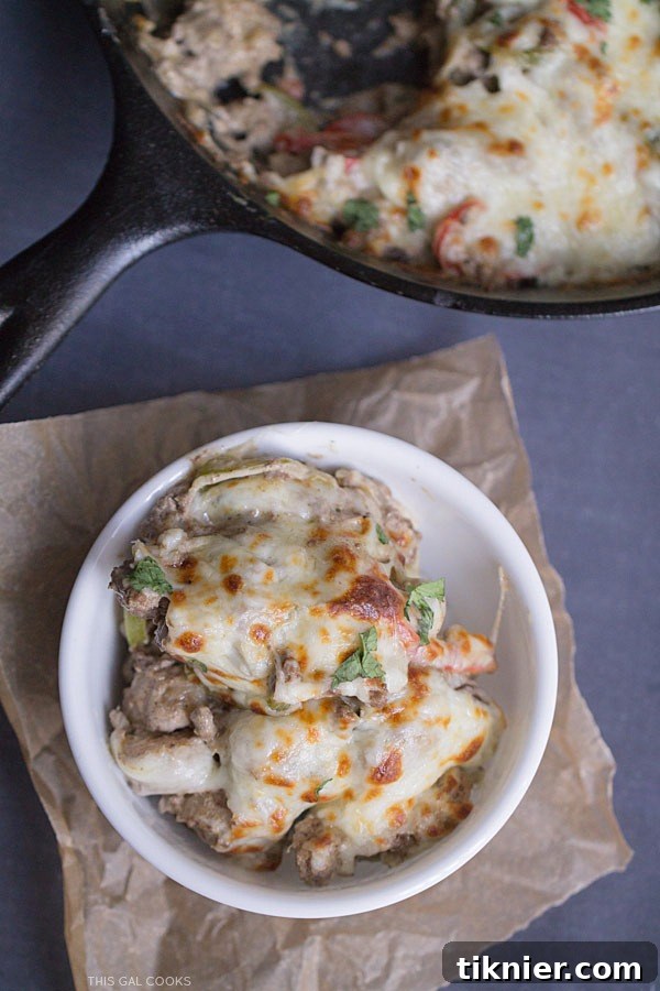 30-Minute Cheesesteak Gnocchi Casserole 7 A close-up of a serving of Philly Cheeseburger Gnocchi Bake garnished with fresh cilantro, showing the creamy texture and melted cheese.