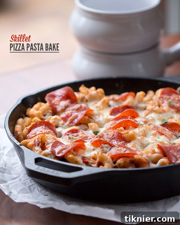 Skillet Pizza Pasta Bake: A delicious and easy one-pan meal featuring hot Italian chicken sausage, turkey pepperoni, rich pizza sauce, fresh vegetables, gluten-free pasta, and melted cheese.