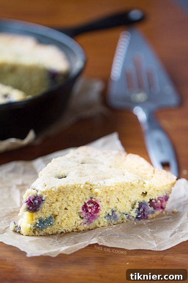 Deliciously moist blueberry cornbread featuring coconut milk, fresh blueberries, and brown sugar, baked in a cast iron skillet.