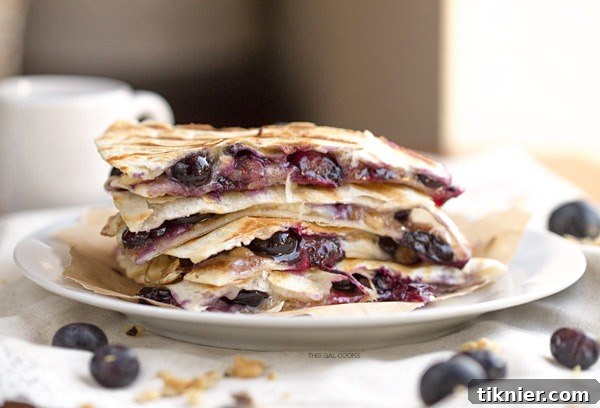 Creamy brie cheese, walnuts and fresh blueberries come together to make this crazy good Blueberry Brie + Walnut Quesadilla. Perfect for breakfast or dessert!
