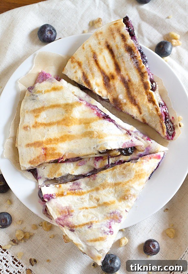 Creamy brie cheese, walnuts and fresh blueberries come together to make this crazy good Blueberry Brie Walnut Quesadilla. Perfect for breakfast or dessert!