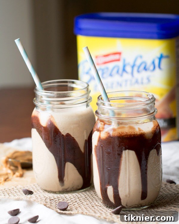 Two glasses of Chocolate Peanut Butter Banana Smoothies garnished with a straw