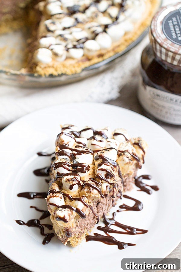 Indulgent S'mores Peanut Butter Chocolate Pudding Pie featuring layers of graham cracker, chocolate, and creamy peanut butter.