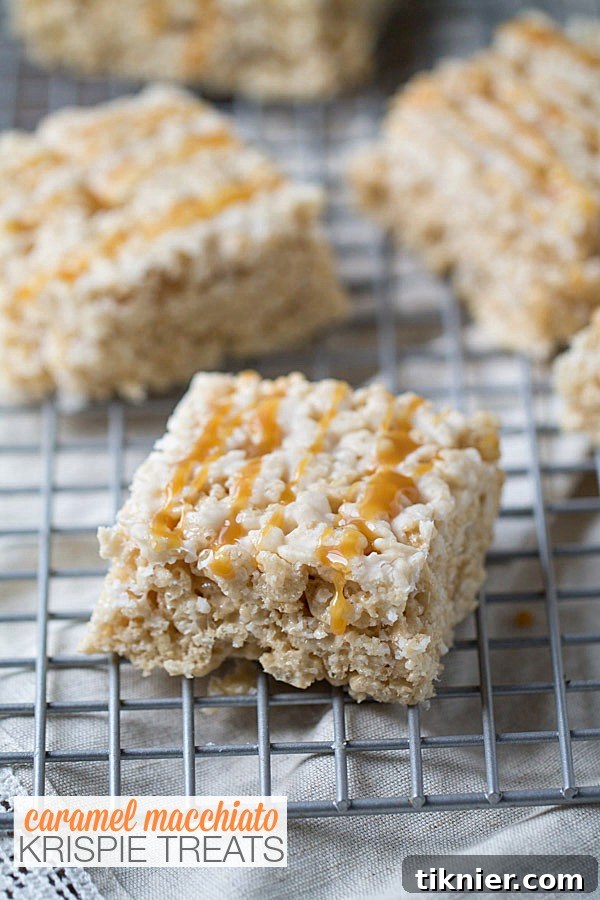 Delicious Caramel Macchiato Krispie Treats on a white plate, drizzled with caramel sauce.