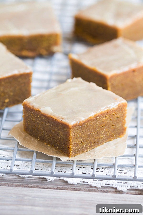 Individual Pumpkin Spice Bars with Bourbon Butter Glaze on a cooling rack, highlighting their moist texture and irresistible topping.
