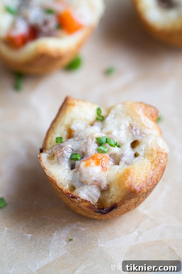Close-up shot of the golden-brown, flaky exterior of a Cheesesteak Crescent Roll Cup, highlighting its perfect texture.