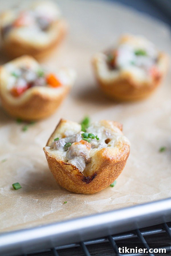 A cluster of baked Cheesesteak Crescent Roll Cups, showcasing the melted cheese and flaky crust.