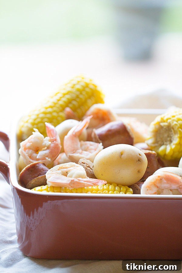 Cooked Low Country Boil ingredients in a serving dish, featuring peeled shrimp and corn