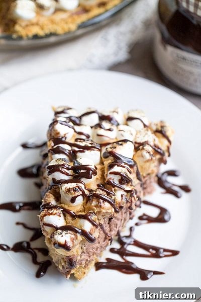 Decadent S'mores Peanut Butter Chocolate Pudding Pie topped with golden toasted marshmallows, rich chocolate drizzle, and crunchy graham cracker crumbs.