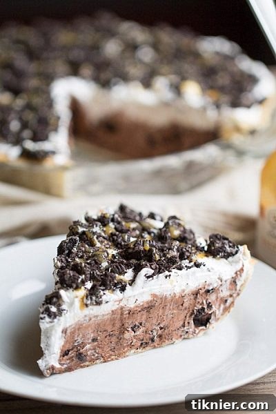 Rich Cookies and Cream Chocolate Pudding Pie, layered with crushed chocolate sandwich cookies and topped with clouds of whipped cream.