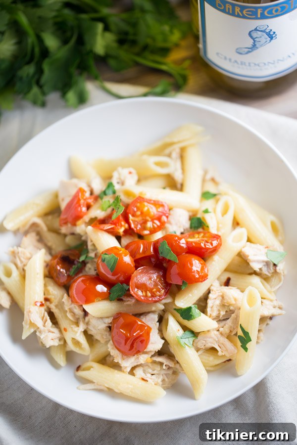 Close-up of freshly cooked One Pan Chicken Pasta with Chardonnay Wine Sauce, showing tender chicken and vibrant tomatoes.