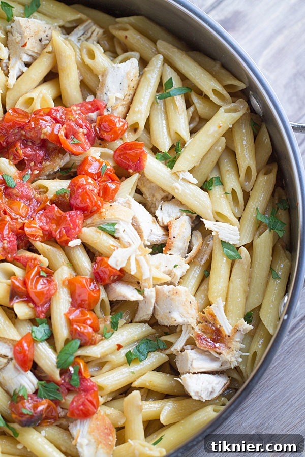 Overhead shot of a serving of One Pan Chicken Pasta with Chardonnay Wine Sauce on a white plate, ready to be enjoyed.