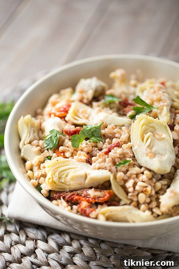 Farro Salad is packed full of tender sun dried tomatoes, artichokes and crunchy pine nuts. Tossed with an olive oil, red wine and Greek seasoning dressing for an outstanding pop of flavor!
