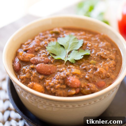 Hearty Beef Chili with Masa Harina, richly garnished with cheese and sour cream.