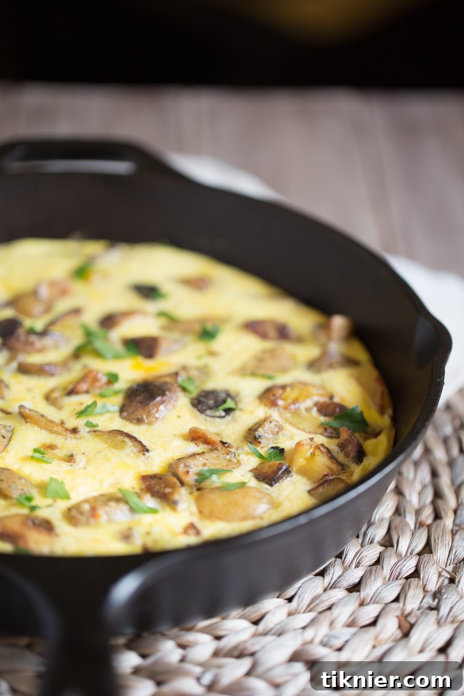 A simple, healthy Potato Frittata with Chicken Sausage and parmesan cheese, garnished with fresh parsley. Ideal for breakfast or brunch. 105 calories/serving.