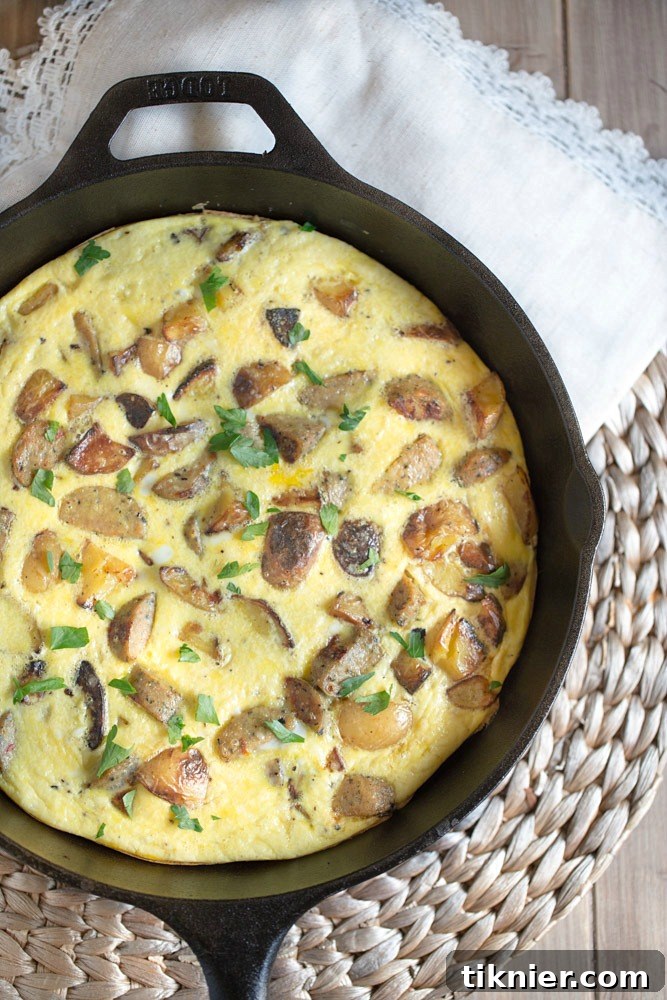 A slice of homemade Potato Frittata with Chicken Sausage, showing the fluffy egg texture, diced potatoes, and savory sausage. A perfect way to use leftovers.