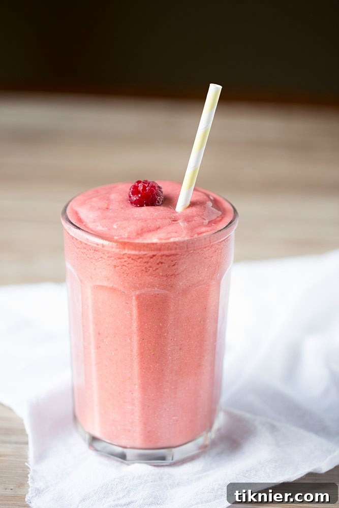 Dairy free, simple and easy to make Tropical Raspberry Coconut Smoothie, beautifully garnished.