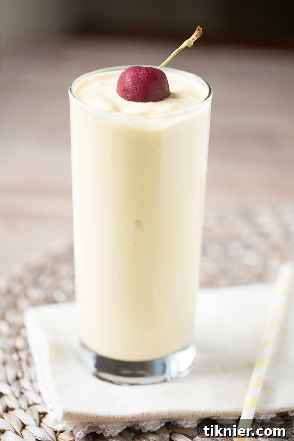 A refreshing dairy-free Pina Colada Smoothie featuring sweet pineapple, creamy coconut milk, and succulent mango, perfect for a tropical breakfast or snack.