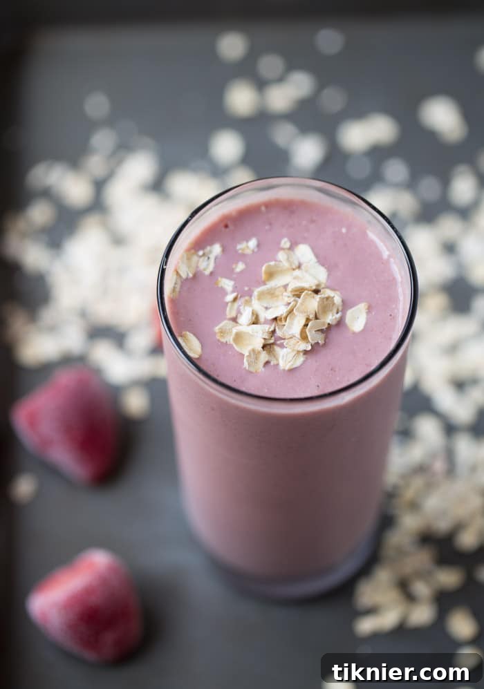 A close-up of a Strawberry Banana Oatmeal Protein Smoothie, showing its creamy texture and fresh strawberry garnish. Ideal for a quick, healthy, and satisfying meal. #smoothie #plantbased #breakfast #vegetarian #realfood #glutenfree