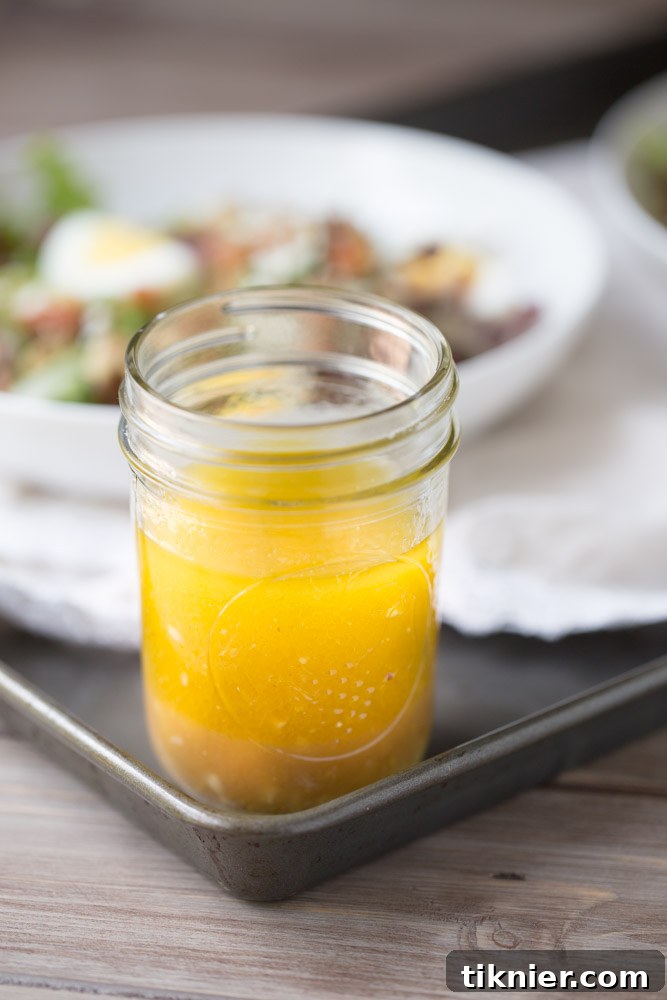 A stunning shot of Honey Balsamic Vinaigrette in a glass jar, perfect for pinning to your recipe board. | This Gal Cooks