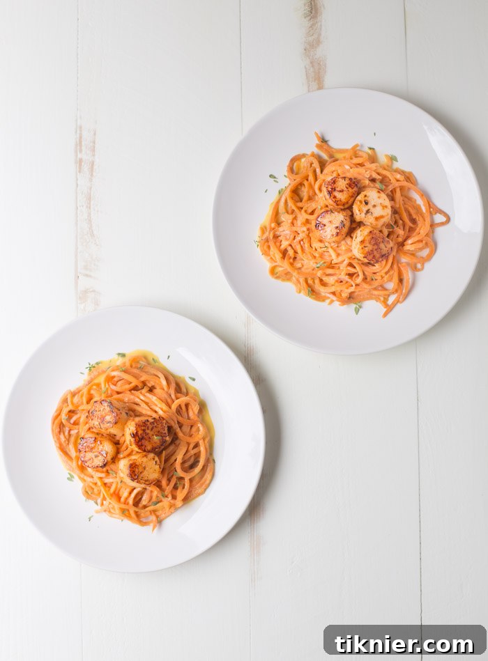 Close-up of perfectly seared Blackened Scallops and vibrant Sweet Potato Noodles, highlighting the dish's texture.