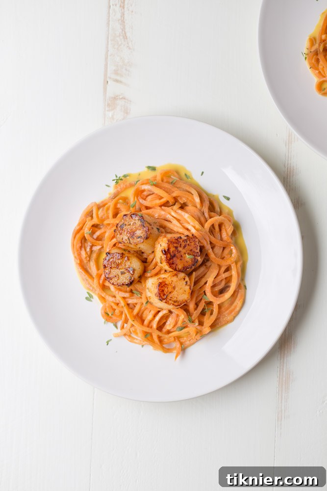 Close-up of a serving of Blackened Scallops and Sweet Potato Noodles with creamy coconut sauce, ready to be enjoyed.