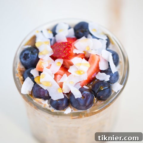Beautifully garnished Overnight Oatmeal Parfait with fresh berries, a vegetarian and gluten-free breakfast.