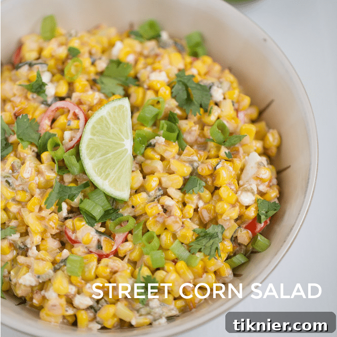 Overhead shot of a bowl of Street Corn Salad with a spoon, ready to serve