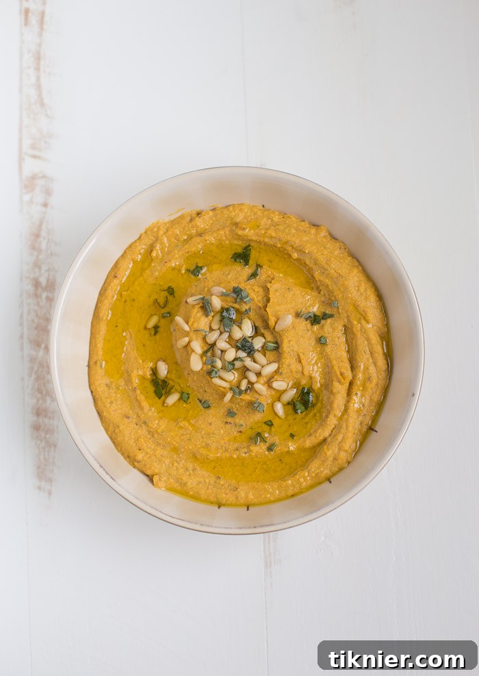 Close-up of creamy Pumpkin Hummus with cranberries and sage, a vegan and easy-to-make dish.