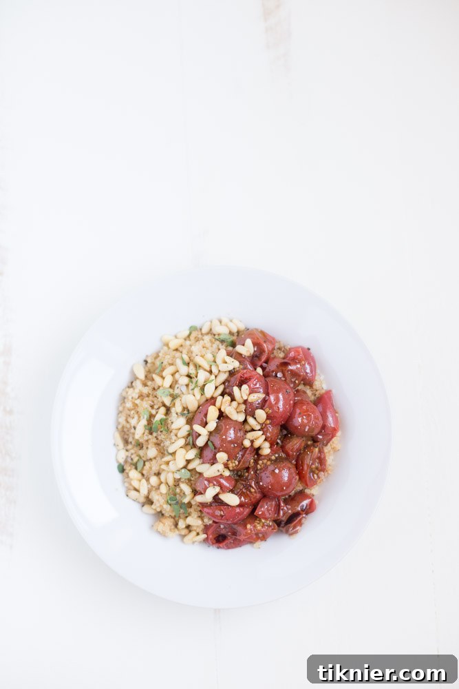 Effortless Vegan Roasted Tomato Quinoa Bowl 3 Close-up of a delicious and healthy Quick Quinoa Bowl with roasted tomatoes, crunchy pine nuts, and fresh thyme, emphasizing its vegan and wholesome ingredients.