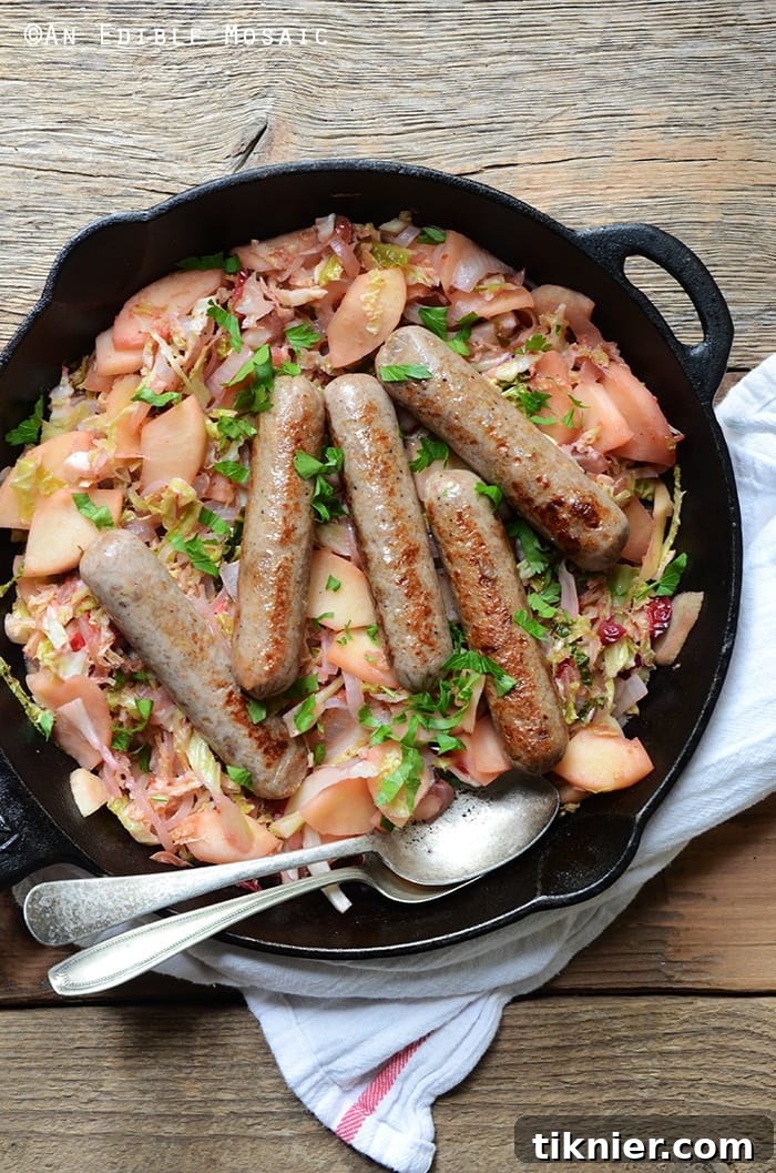 A hearty Paleo Chicken Sausage Skillet, brimming with colorful cabbage, apple slices, and cranberries, cooked to perfection.
