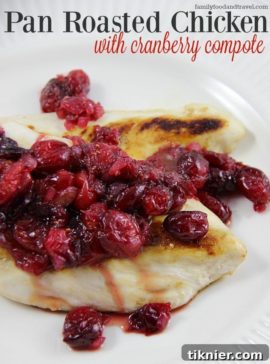 Golden-brown Pan Roasted Chicken served with a generous spoonful of vibrant Cranberry Compote, artfully plated with herbs.