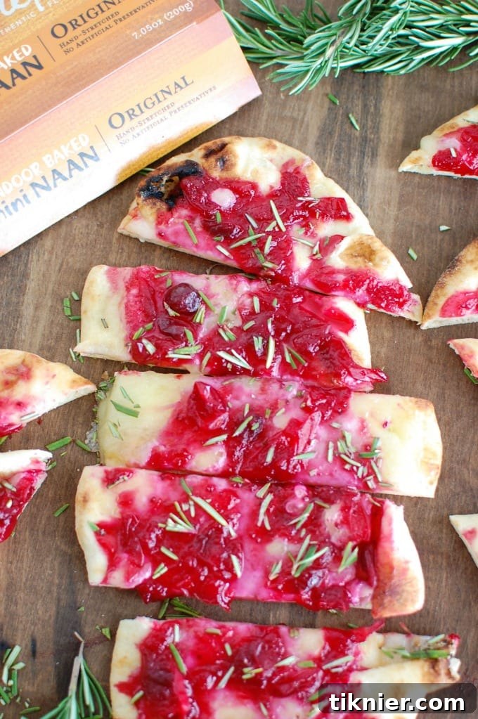 Warm Brie Cranberry Naan, freshly baked with melted brie cheese and a rich cranberry spread, garnished with herbs.